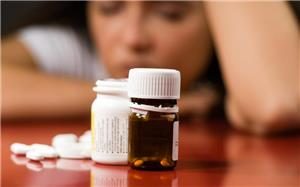 Woman looking at pill bottle dealing with depression