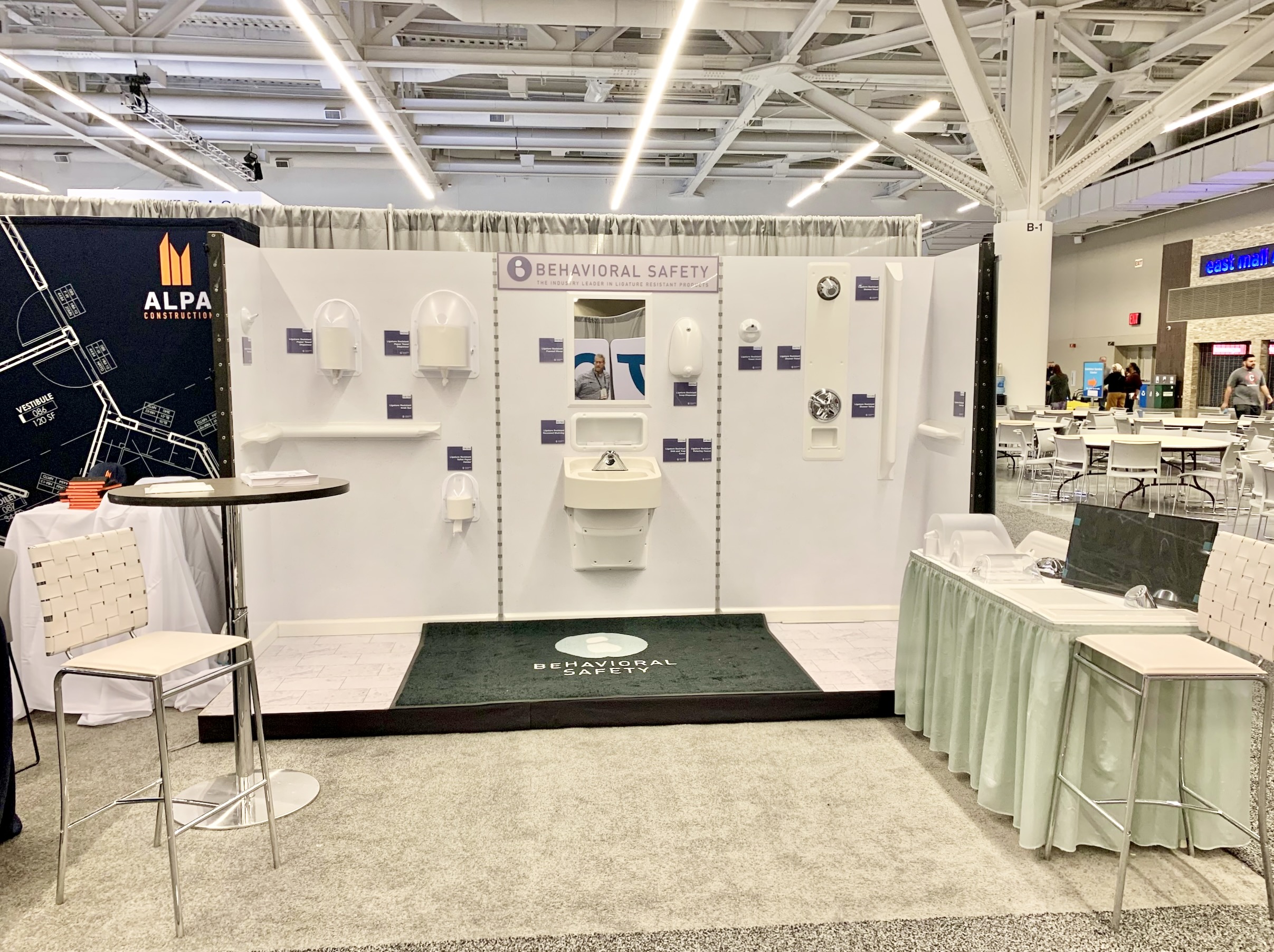 an image of a booth by Behavioral Safety Products, showing ligature resistant products in a bathroom, in a well-lit conference center